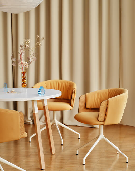 Nowoczesne krzesła tapicerowane Collar w kolorze miodowym przy okrągłym stole w jasnym wnętrzu