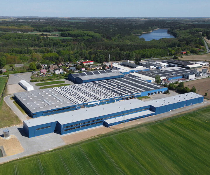 Widok z lotu ptaka na nowoczesną fabrykę mebli biurowych otoczoną zielenią