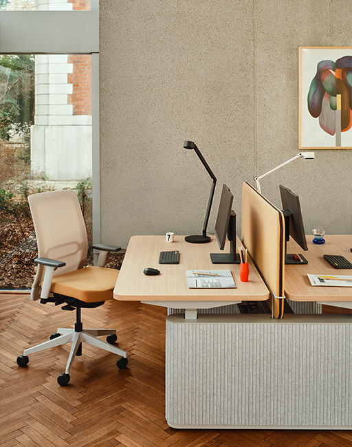 Drewniana komoda na metalowych nogach z lamelowym frontem, ustawiona przy oknie