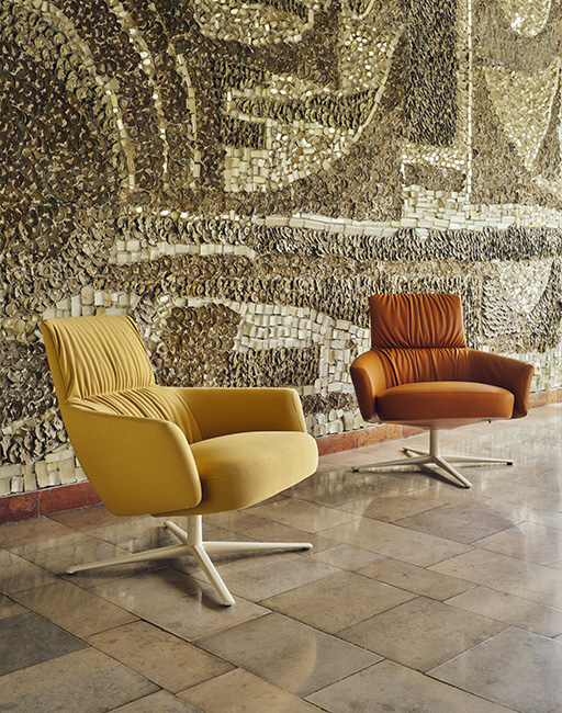 Dwa tapicerowane fotele lounge w odcieniach brązu na obrotowych metalowych podstawach