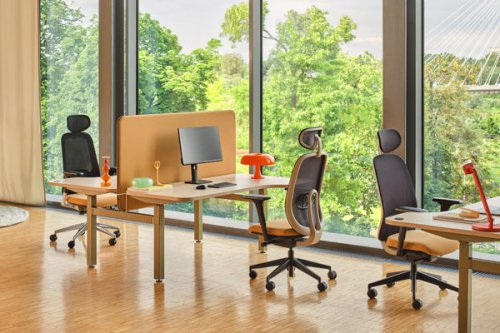 Ergonomiczne meble biurowe w nowoczesnym biurze z dużymi oknami