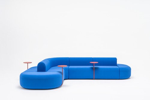 Niebieska modułowa sofa w przestrzeni biurowej z małym stolikiem pomocniczym