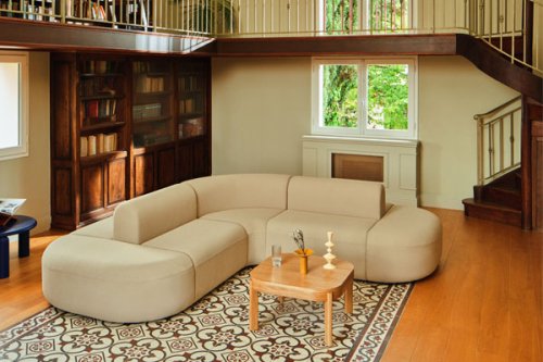 Niebieska modułowa sofa w przestrzeni biurowej z małym stolikiem pomocniczym